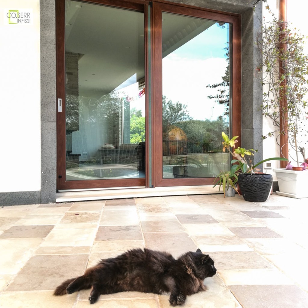 Porta alzante scorrevole bicolore in alluminio effetto legno con zanzariera, installata in villa ad Augusta