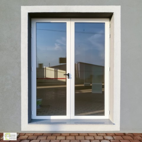 Porta finestra a due ante in allumnio bianco con maniglione antipanico per attività commerciale ad Augusta Porta finestra a due ante in allumnio bianco con maniglione antipanico su muro grigio e cornice bianca per attività commerciale ad Augusta