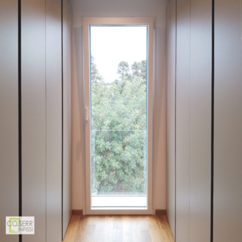 Porta a vetro in alluminio con ribalta e balaustra in vetro installata a Siracusa da Co.Serr Porta finestra con ribalta in alluminio bianco con balaustra per cabina armadio progetto di architetto a Siracusa
