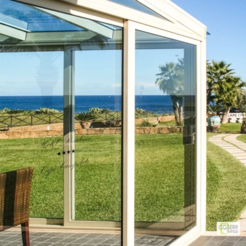 Veranda in allumnio installata al resort Capo Campolato ad Augusta porte scorrevoli e tettoia a vetro e alluminio bianco installata da Co.serr ad Augusta